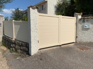 Entrée vue côté rue avec portail alu beige et clôture à Châtillon